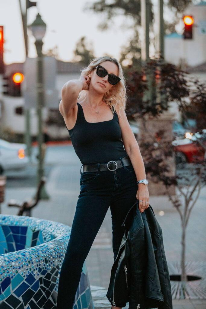 Jaquelyn Wahidi, San Diego Fashion Blogger, reviews MOTHER Denim jeans in front of a fountain.