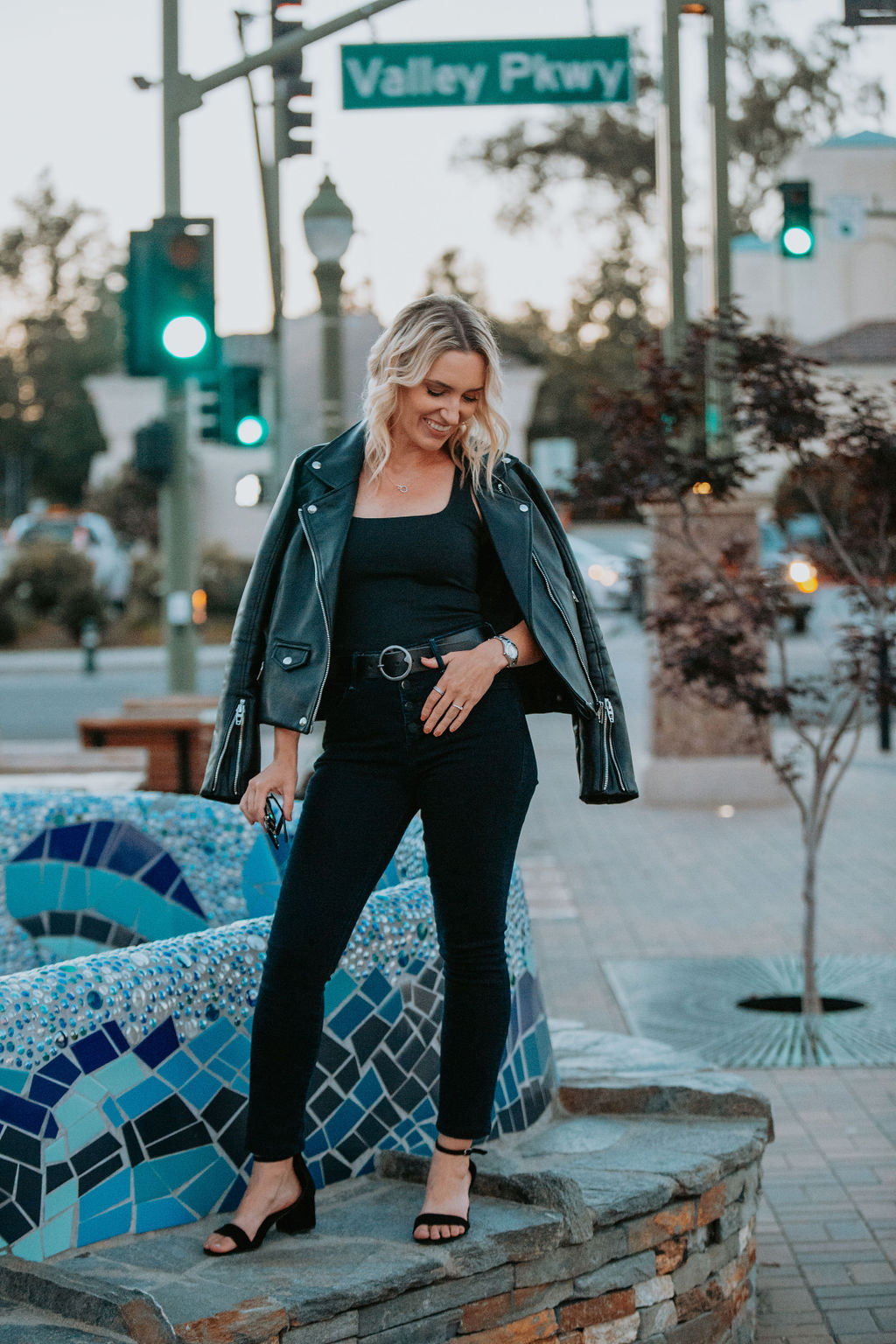 Fashion stylist Jaquelyn Wahidi reviews MOTHER Denim in front of a fountain.